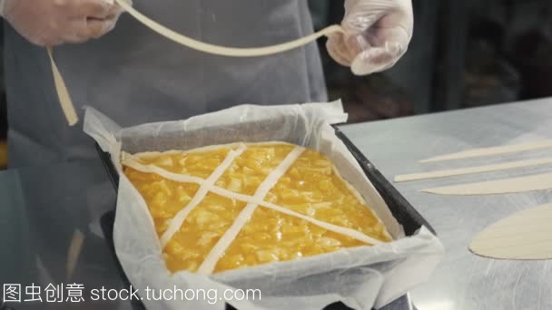 人準備水果橙色檸檬餡餅在廚房桌上, 最后的裝飾在手套, 餐廳廚房烘焙產(chǎn)品工廠